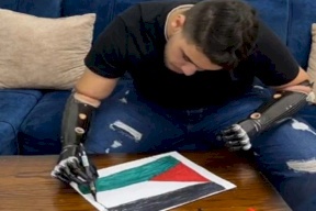 “فتى الزرقاء” يرسم علم فلسطين بذراعيه الاصطناعيتين