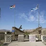 The Jordanian and Israeli flags fly over the Baquoura Bridge on the border