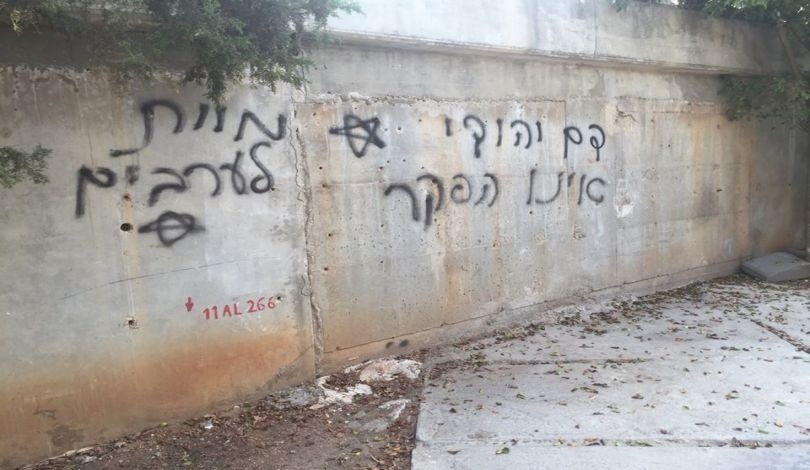 مستوطنون يحرقون جرافة ويخطون شعارات عنصرية في قرية بورين جنوب نابلس