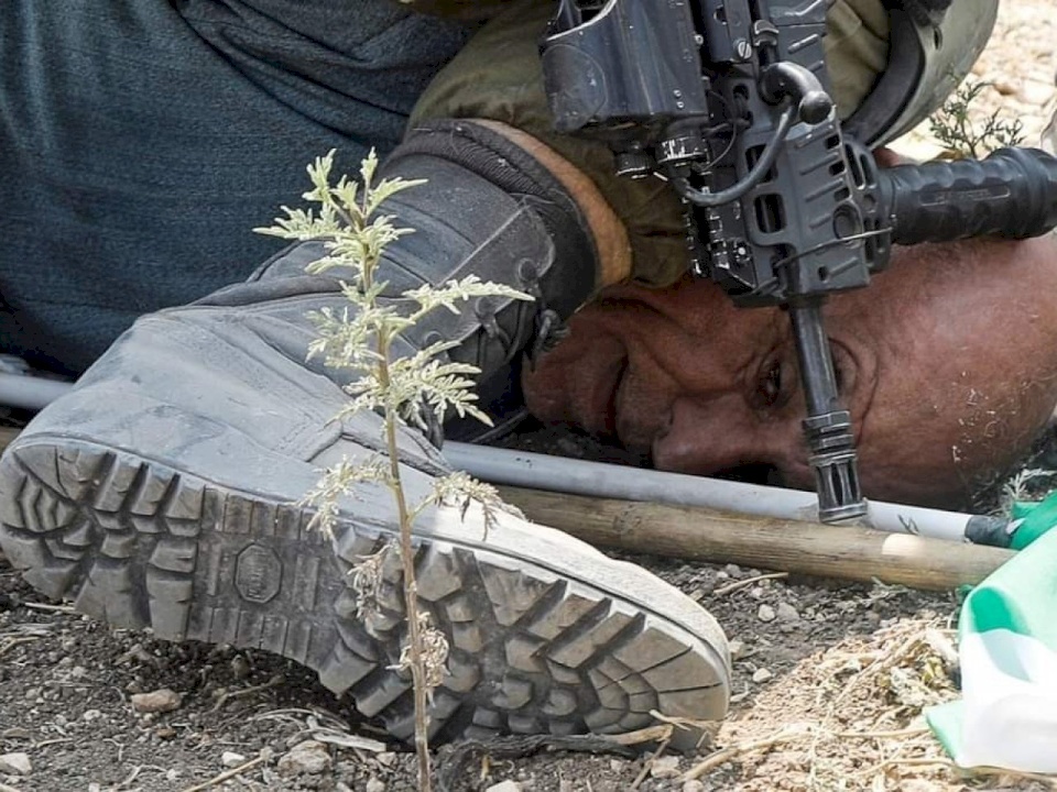 إيران تعلق على جثم جندي إسرائيلي بركبته فوق عنق مسن فلسطيني