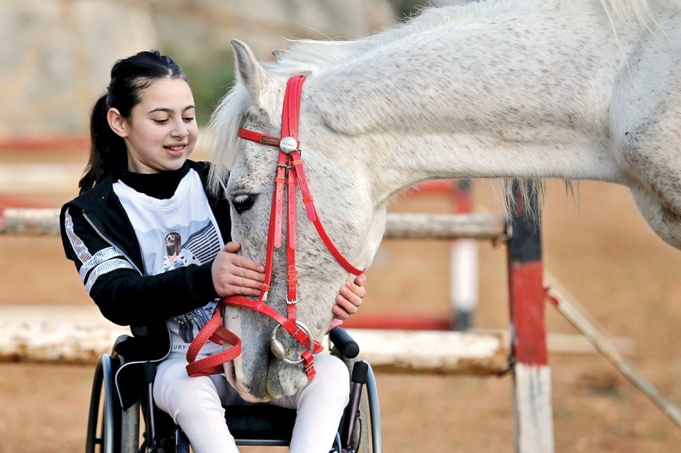 ركوب الخيل يساعد طفلة فلسطينية مصابة بشلل نصفي