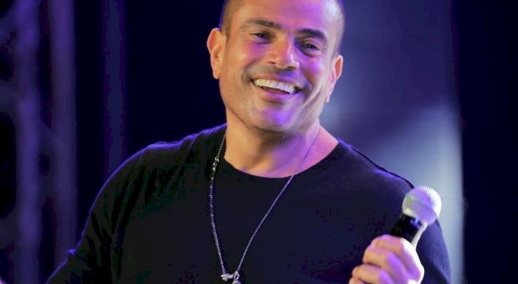 معجبة تلفت انتباه عمرو دياب وتشتته خلال مقابلة تلفزيونية! (شاهد)